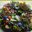Bloemenkrans met rozenbottels en distels